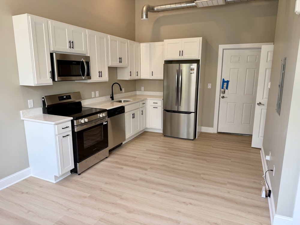 Apartment 1 kitchen with stainless range and refrigerator.