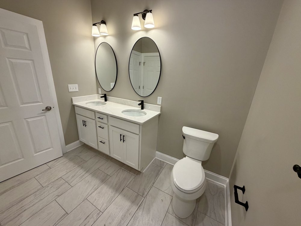 Apartment 3 double vanity with two round mirrors.
