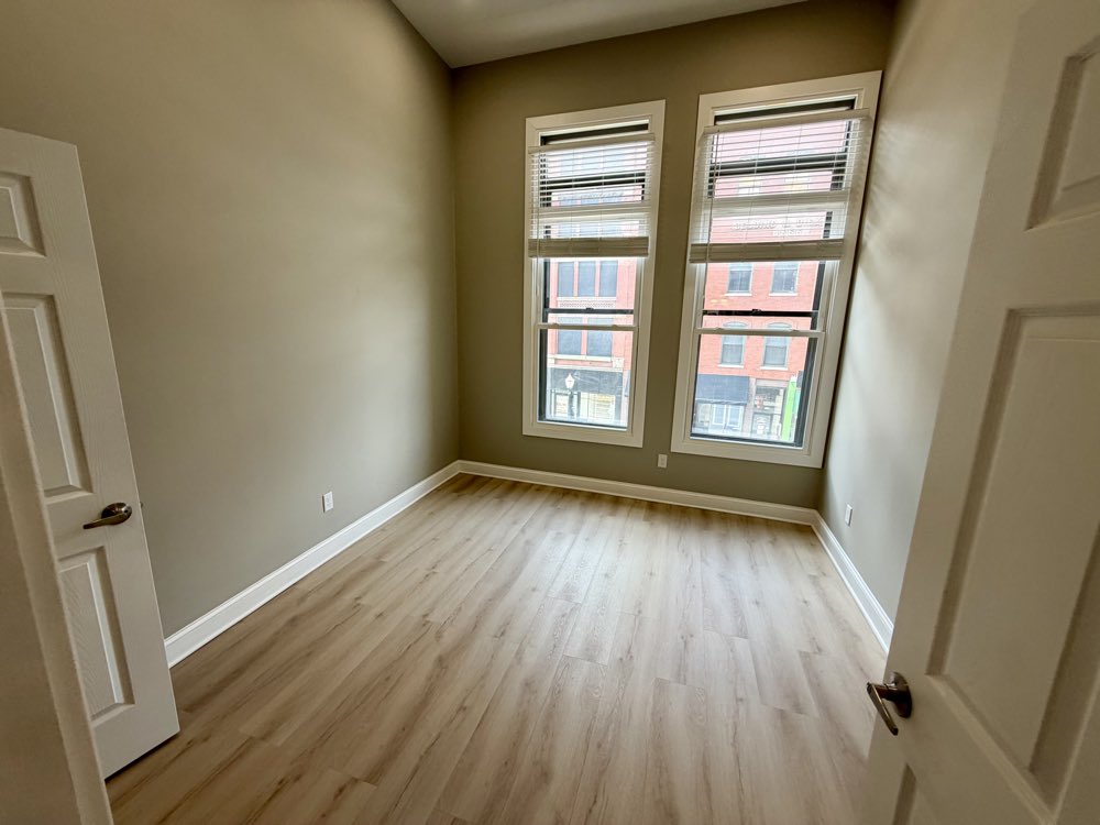 Apartment 4 bedroom with three tall windows.