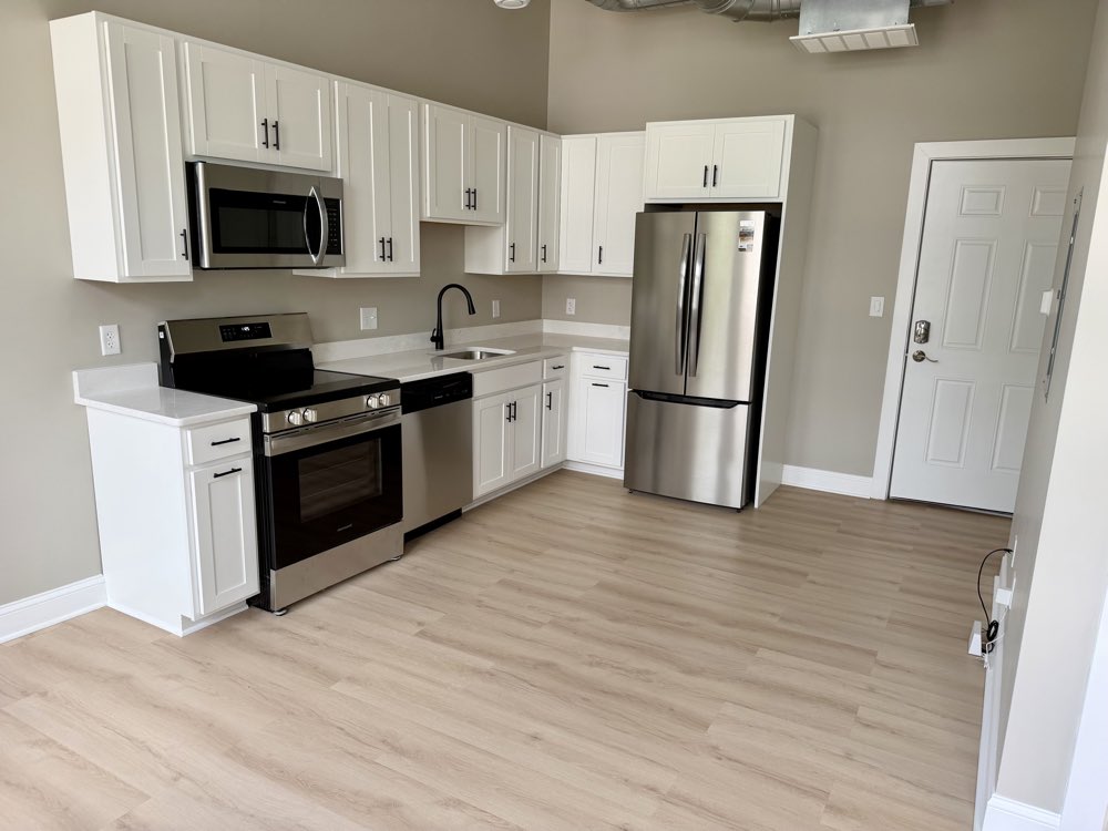 Apartment 5 — kitchen with stainless appliances and white cabinetry.