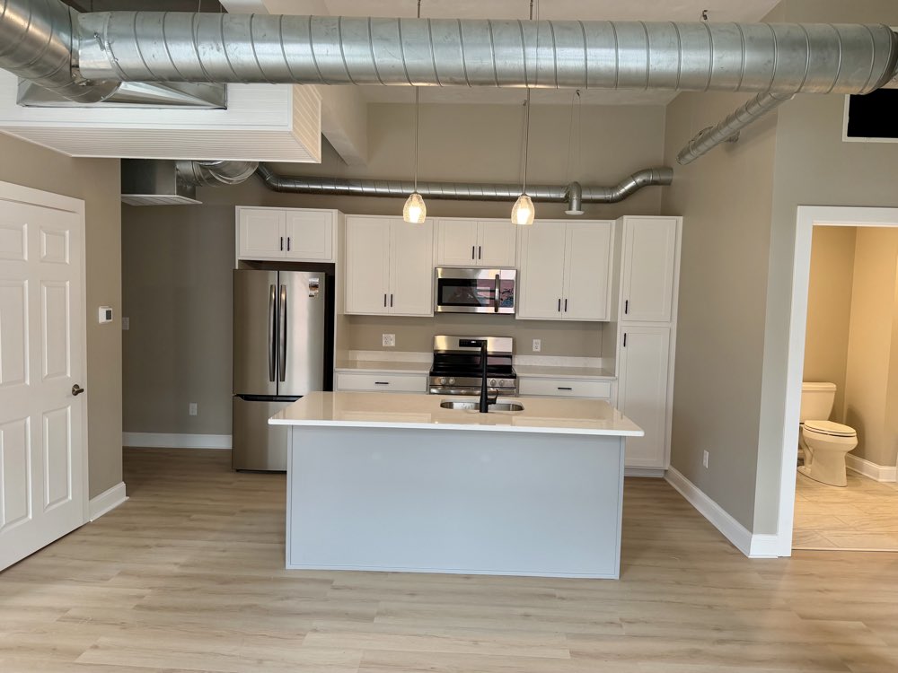 Apartment 8 — island kitchen under exposed ductwork.