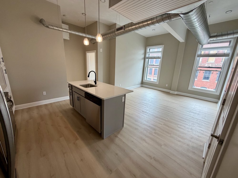 Apartment 8 island and living area with tall windows.