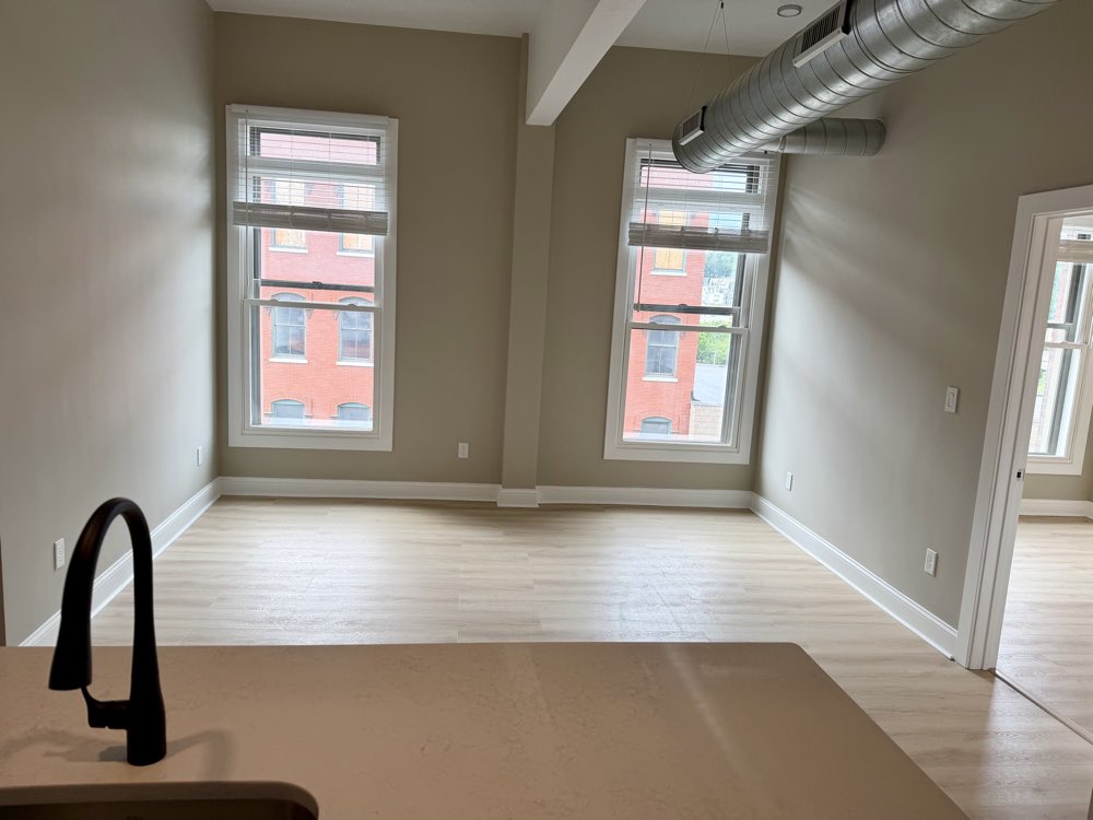 Apartment 8 living area with exposed brick between the windows.
